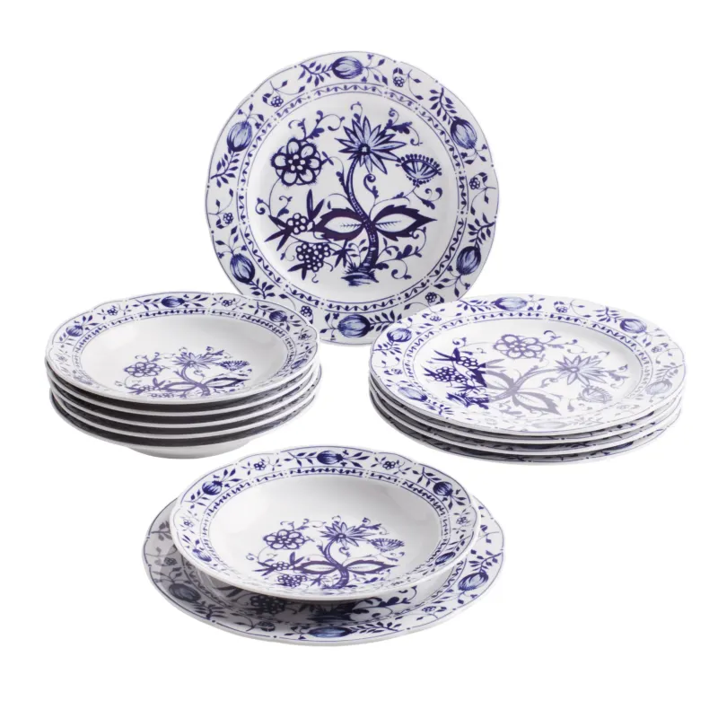 Ein Set aus mehreren weißen Tellern mit blauem, floralen Motiv. Es besteht aus einem flachen Teller und mehreren tiefen Tellern, die übereinander gestapelt sind. Der flache Teller ist mit einem detaillierteren Muster verziert, während die tiefen Teller ein ähnliches, jedoch einfacheres Design aufweisen. Die Teller haben einen klaren, klassischen Stil, der gut für Tischdekorationen geeignet ist.